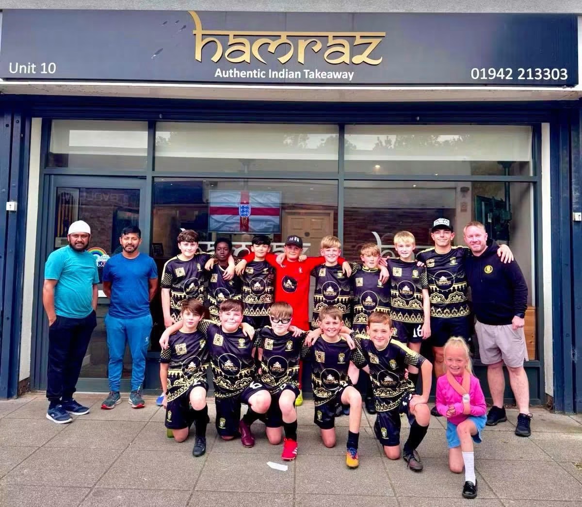 FC Wigan team in Hamraz sponsored kit outside Hamraz Indian Takeaway